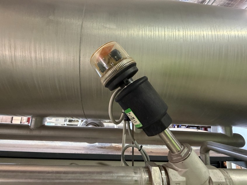Angled solenoid valve assembly installed on process pipework.